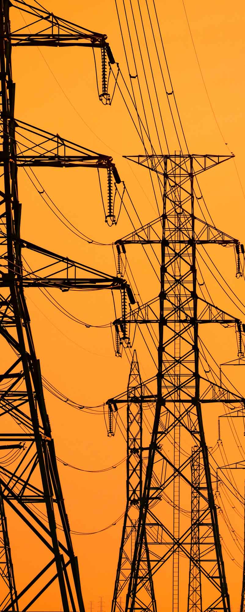 High Voltage Electric Pole And Transmission Lines In The Evening High voltage electric pole and transmission lines in the evening. Electricity pylons at sunset. Power and energy. Energy conservation. High voltage grid tower with wire cable at distribution station.